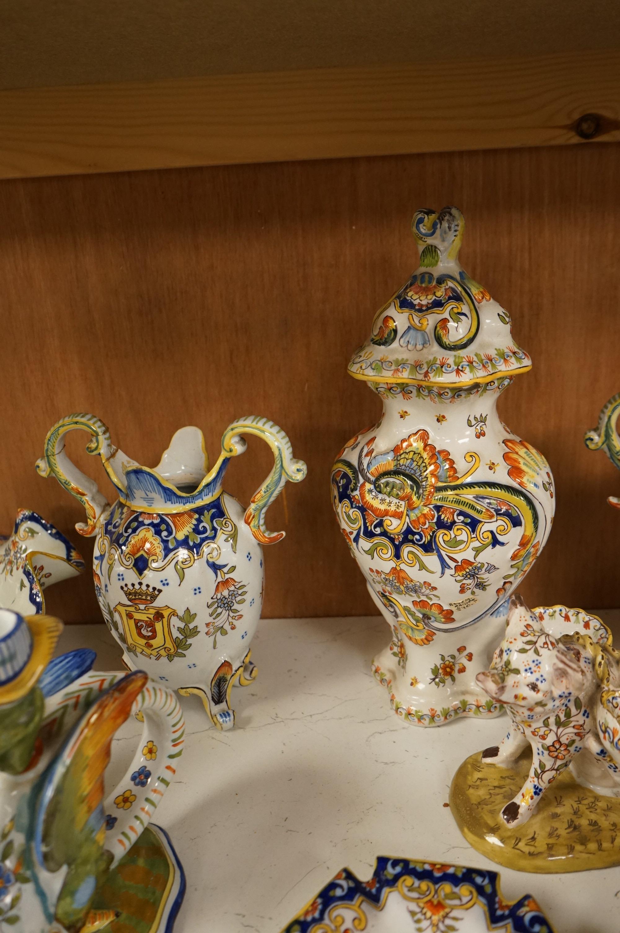 A collection of early 20th century French faience pieces to include a pair of salts in the form of pigs and candlesticks, largest 27cm high